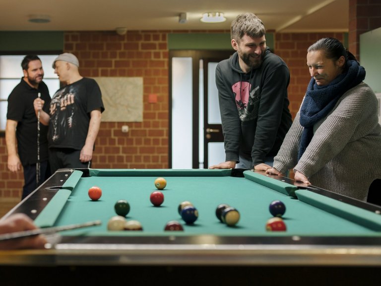 Bild einer geselligen Billardrunde mit fünf Personen.